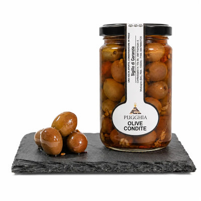 Un barattolo in vetro trasparente di olive condite al naturale pugglia da 314 g con coperchio nero e etichetta in grassetto