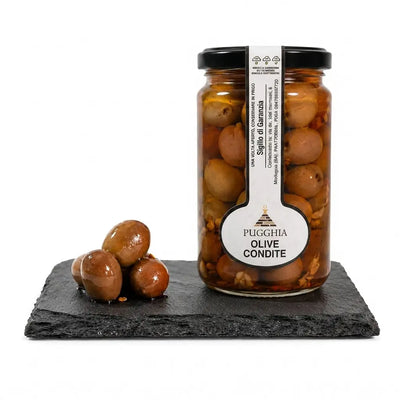 Barattolo di condimento di olive puglia da 314 gr con etichetta bianca, scritte dorate e olive marroni lucide in salamoia